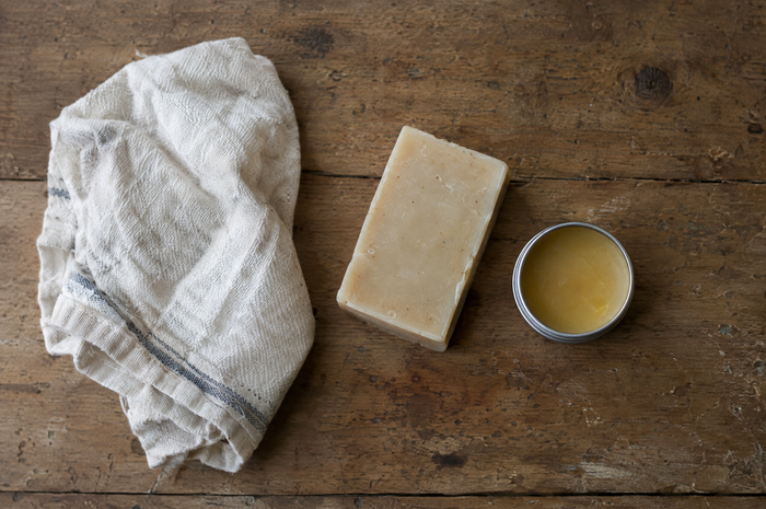Soft cloth, mild soap and olive oil beside a hammered copper sink