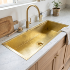 40 inch hammered brass kitchen sink with brass basket strainer in a white marble counter