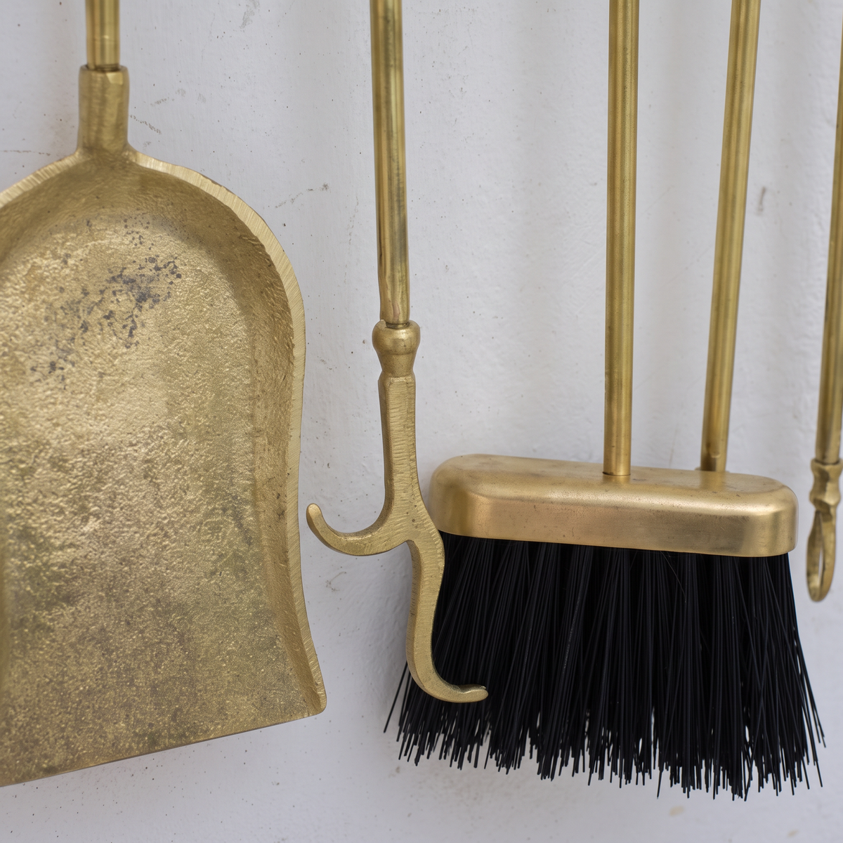 Close-up of the mottled brass shovel, poker hook and black-bristle brush