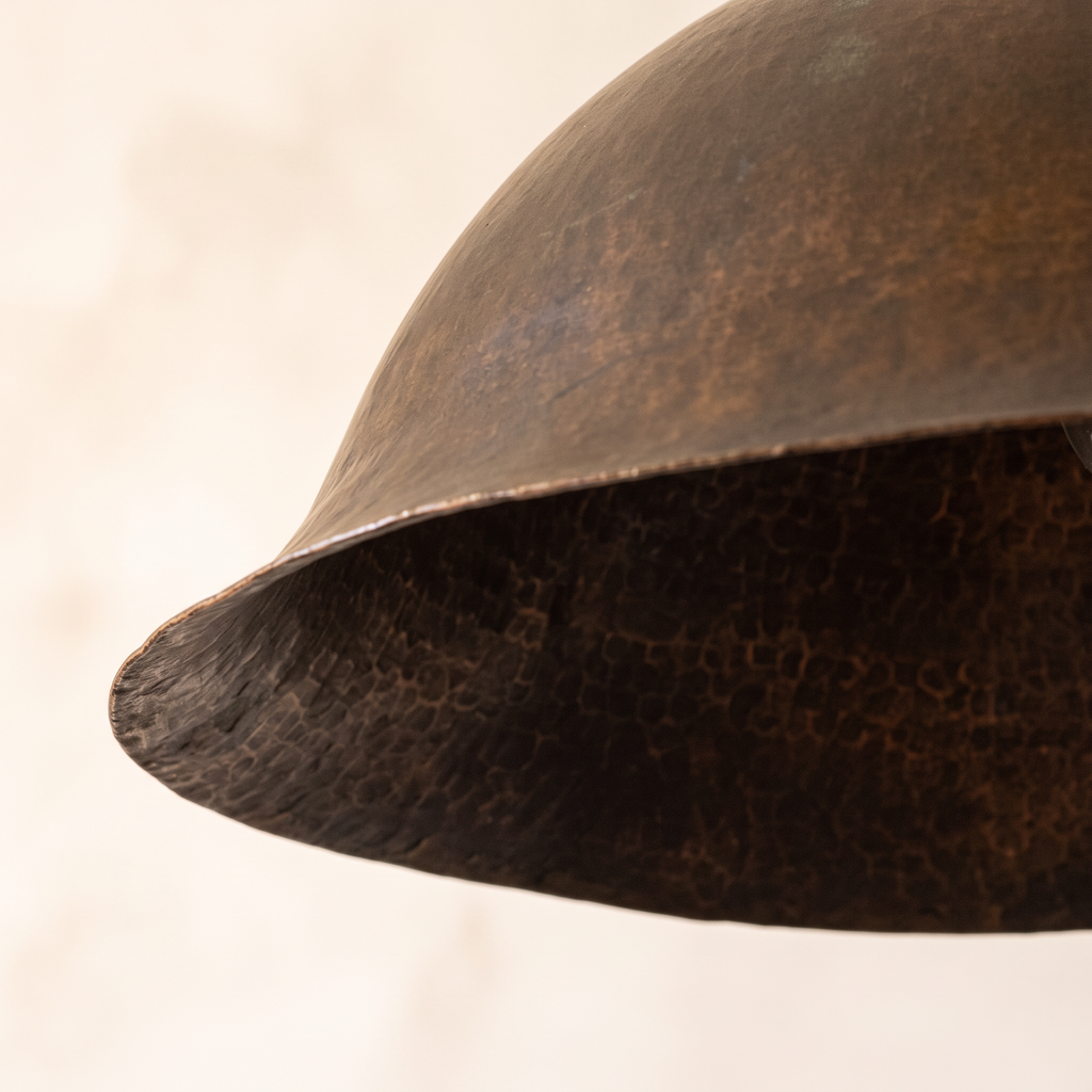 Flared rim and hand-hammered interior of the aged copper bell pendant