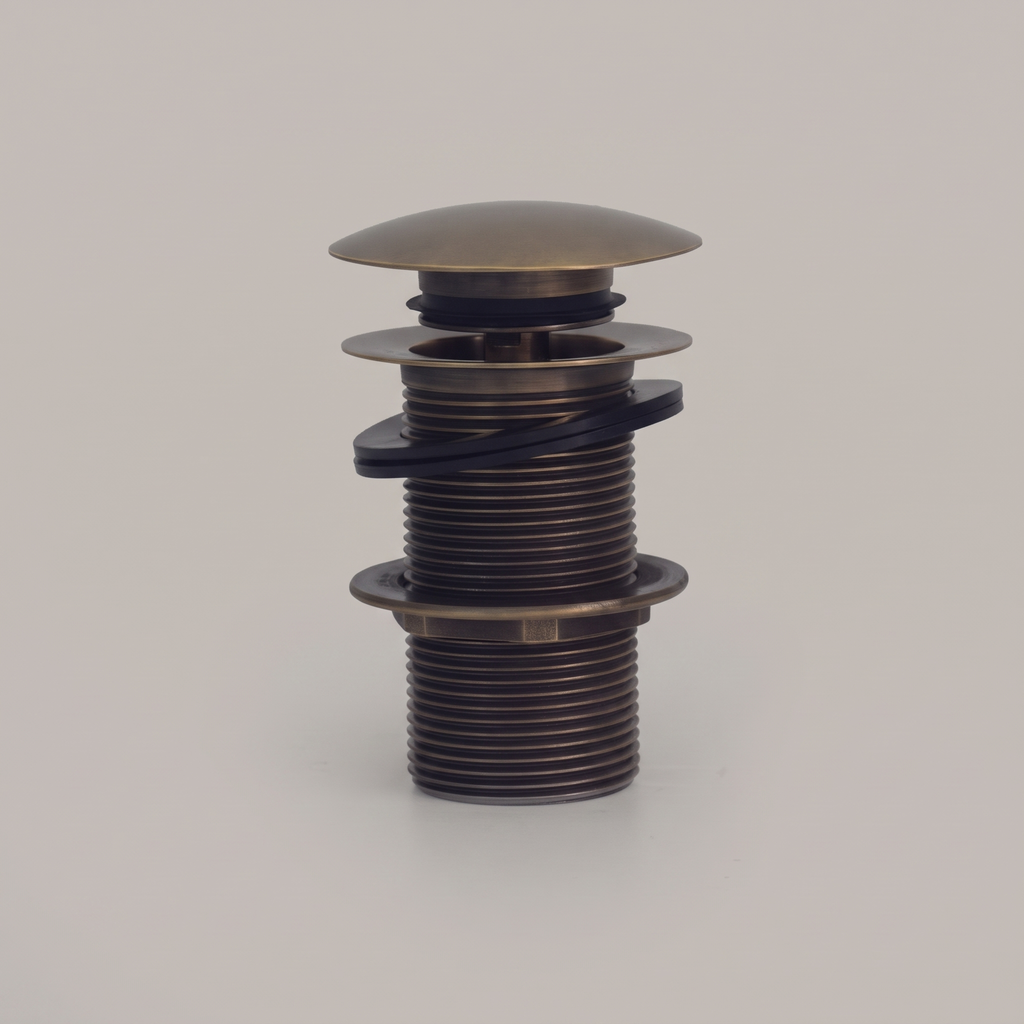 Antique brass push pop-up sink drain with domed cap on a light background