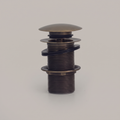 Antique brass push pop-up sink drain with domed cap on a light background
