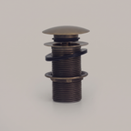 Antique brass push pop-up sink drain with domed cap on a light background