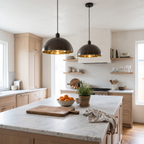 Two antique bronze dome pendant lights with brass interiors over a marble kitchen island