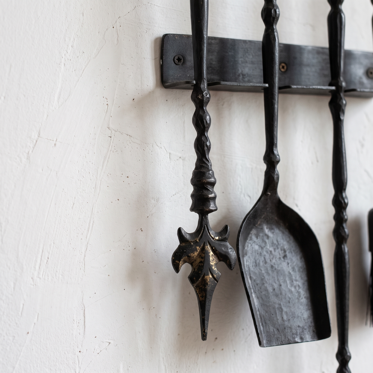 Close-up of the leaf-shaped poker tip and twisted handles in dark black brass