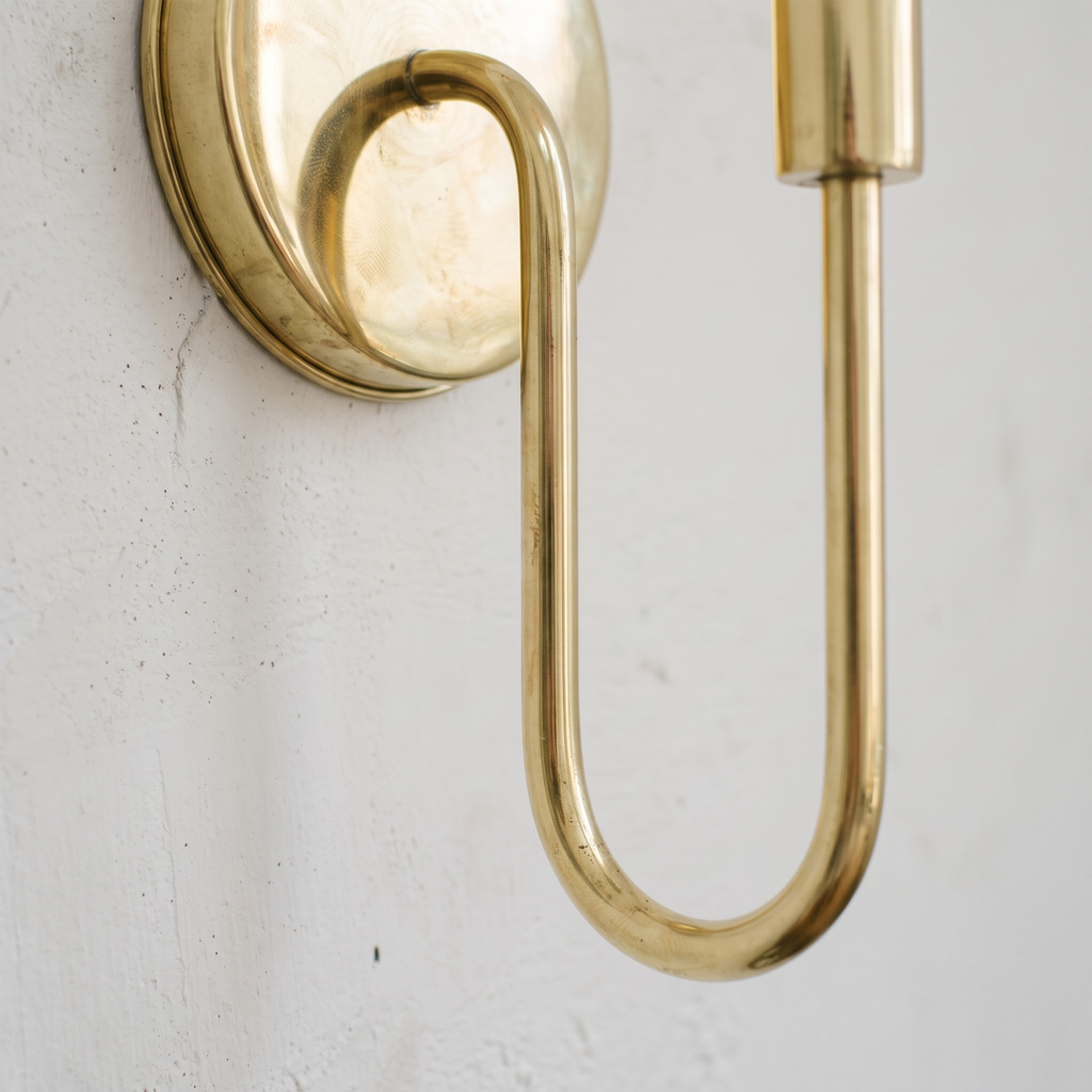 Close-up of the U-curved unlacquered brass arm and round backplate