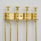Close-up of the brass wall bar and turned disc-top posts of the fireplace tool rack