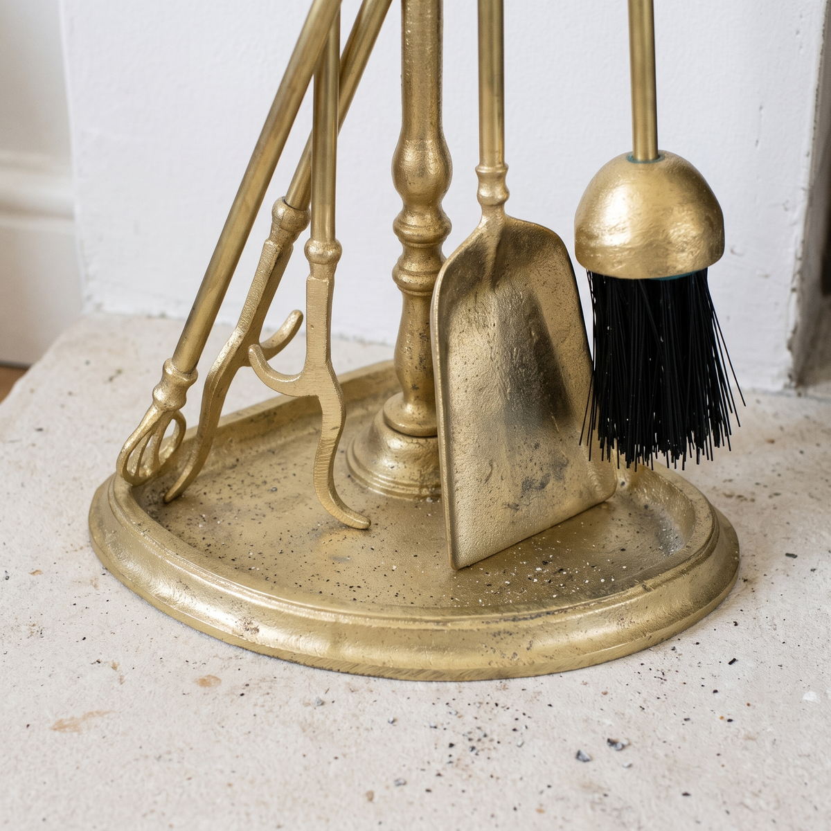 Close-up of the half-round brass tray base with shovel, brush and tongs tips