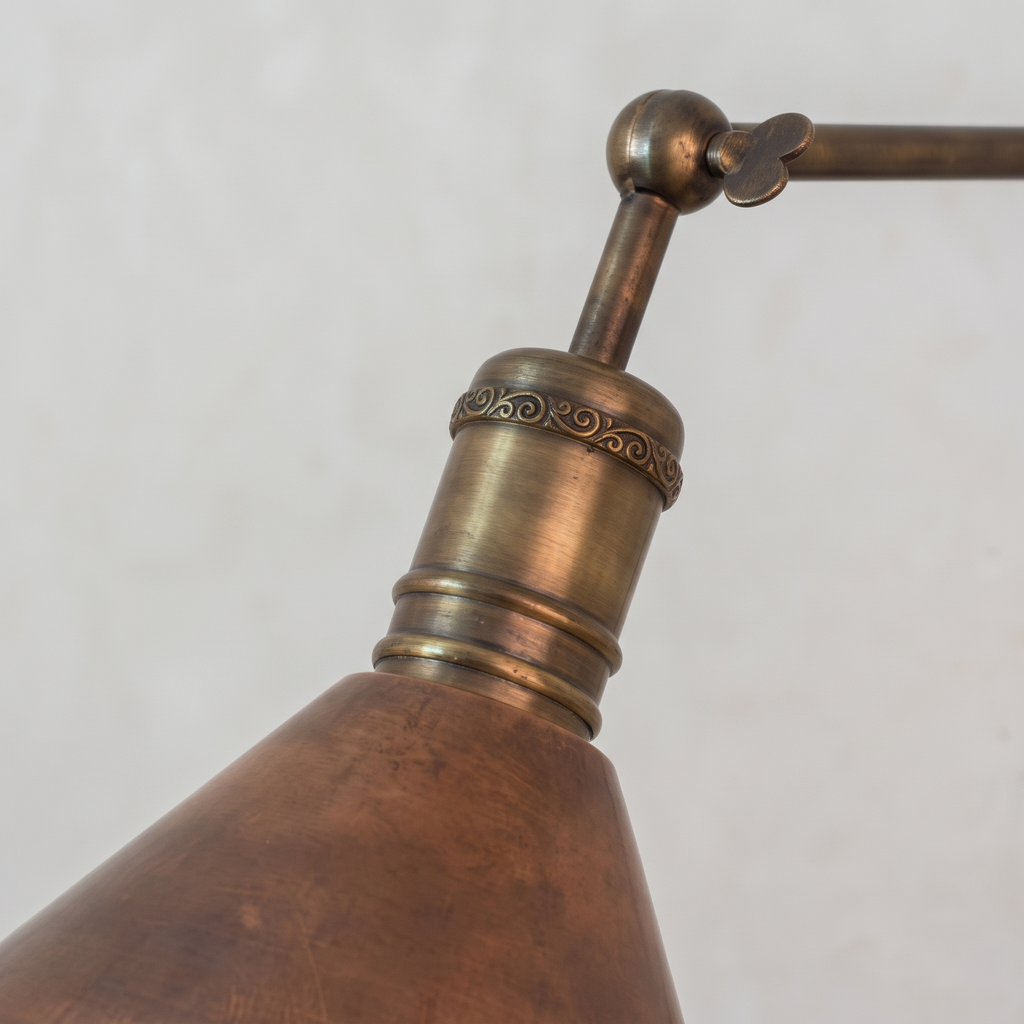 Close-up of the scrolled brass socket band, ball joint and aged copper shade