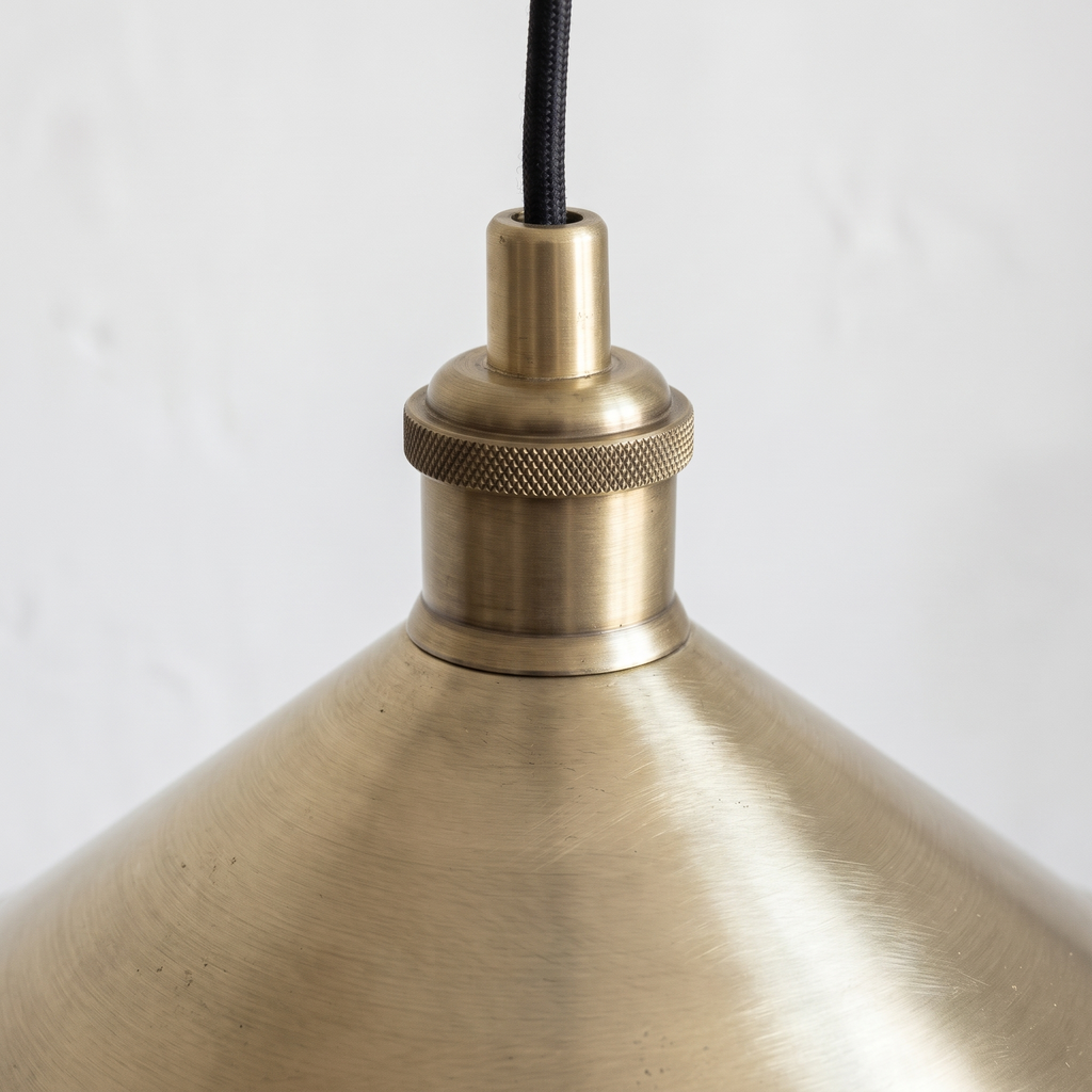 Close-up of the brushed brass finish and knurled socket holder of the cone pendant