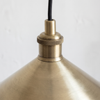 Close-up of the brushed brass finish and knurled socket holder of the cone pendant