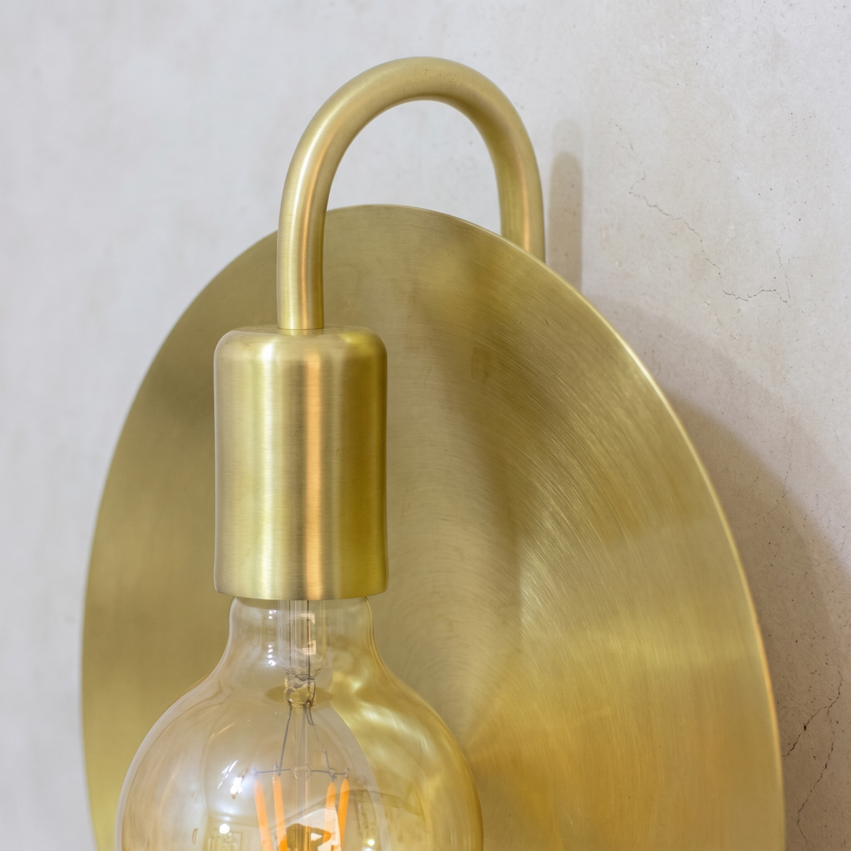 Close-up of the brushed brass socket, hooked arm and disc grain