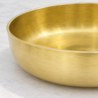 Close-up of the brushed brass surface and thin rounded rim