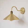 Brushed brass swan neck wall sconce with cone shade and antique brass socket, side view
