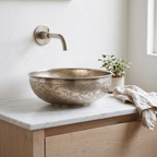 Engraved German silver vessel sink on a white oak vanity in a bright guest bathroom