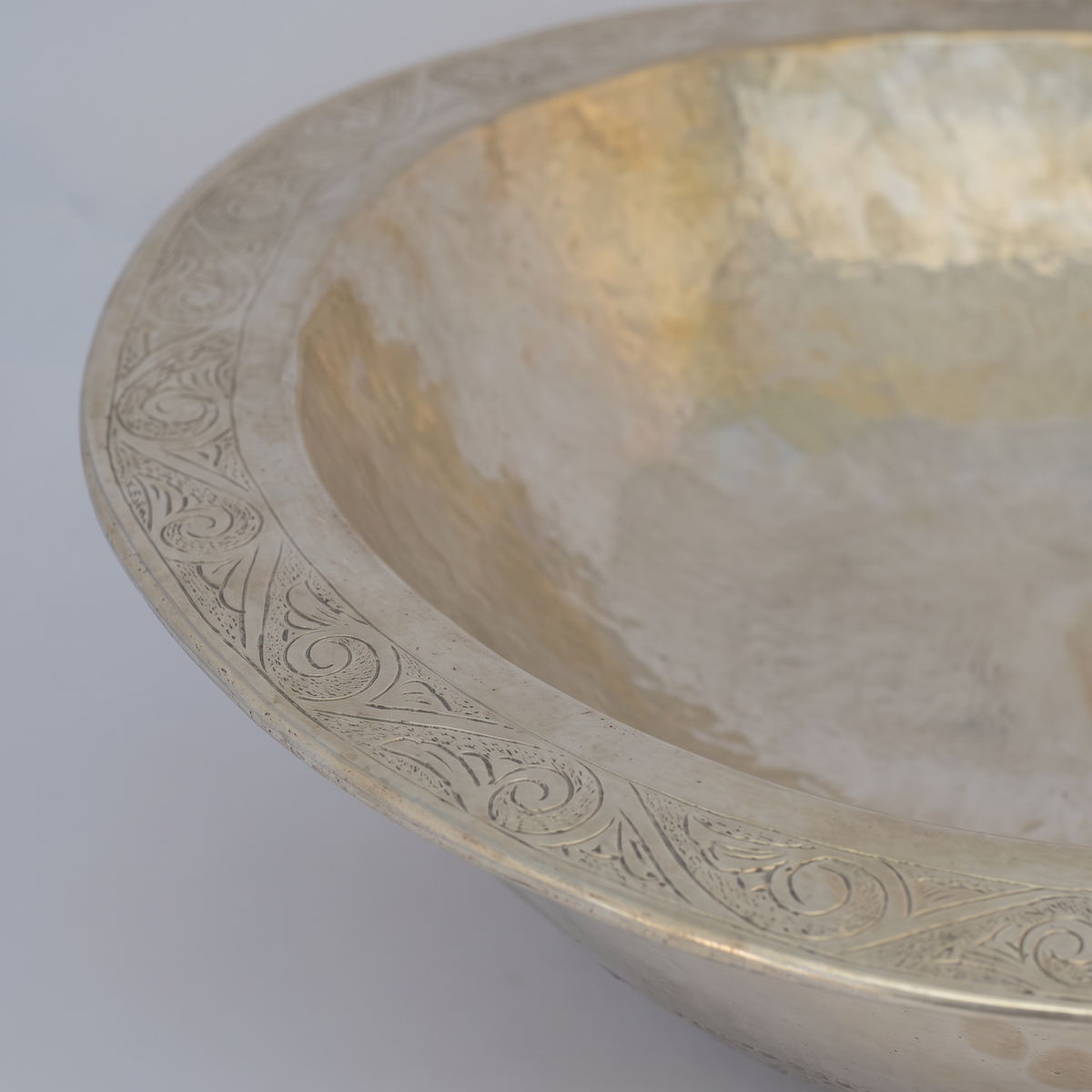 Close-up of the engraved border on the double rim of an oval German silver sink