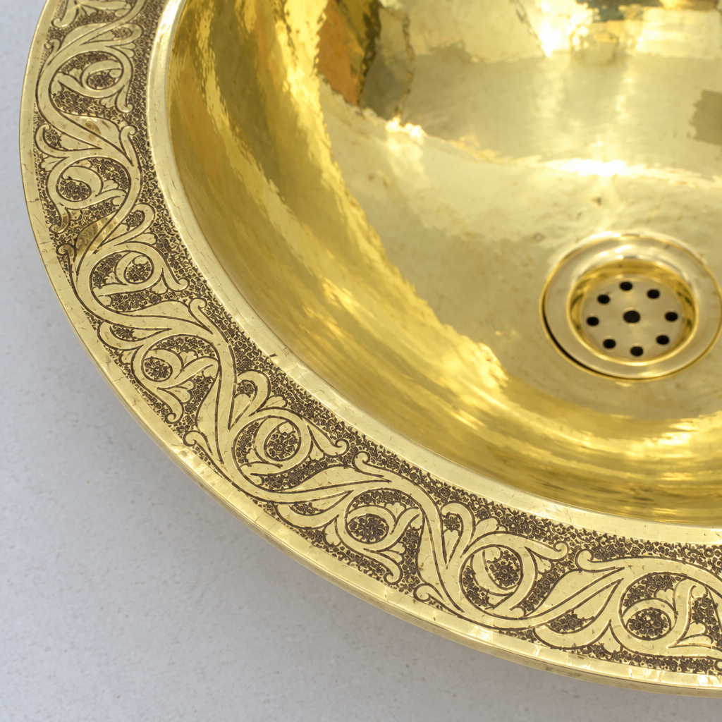 Close-up of the engraved scrolling vine pattern on the brass rim