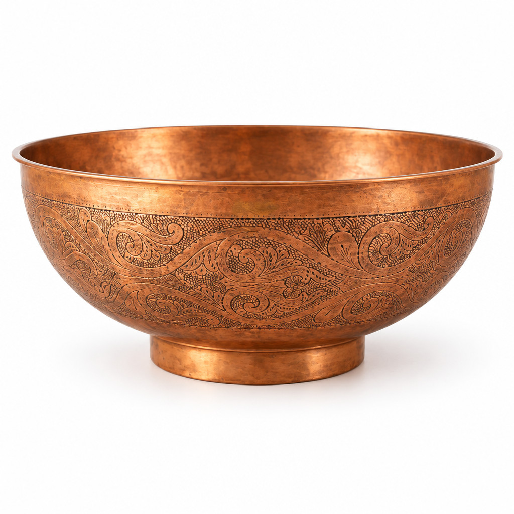 Engraved round copper vessel sink with raised foot on a white background