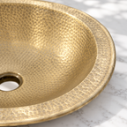 Hammered Oval Brass Drop-In Bathroom Sink, close-up of the wide rim and hammered texture