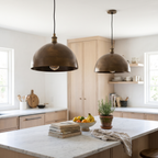 Two hammered antique bronze dome pendant lights over a white marble kitchen island