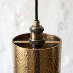 Antique brass socket on a crossbar inside the hammered brass cylinder