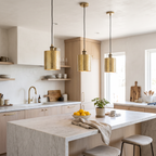 Three hammered brass cylinder pendant lights over a white marble kitchen island