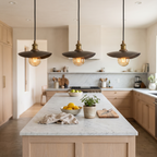 Three hammered bronze finish curved plate pendant lights over a white marble kitchen island