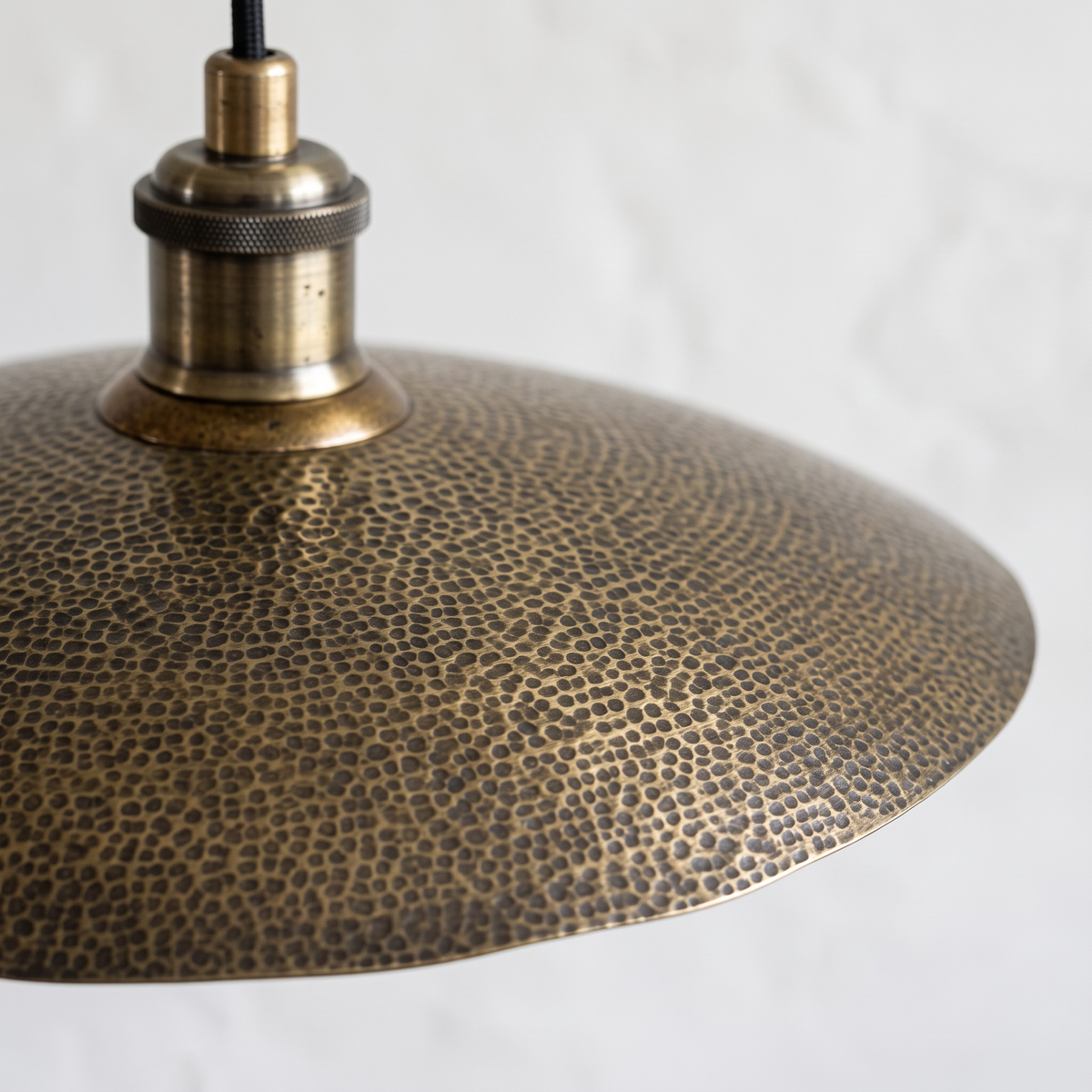 Pebbled hammered texture and antique brass socket of the saucer pendant