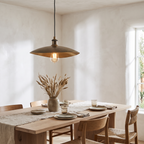 Hammered bronze finish saucer pendant over a white oak dining table