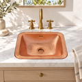 Hammered Copper Drop-In Bathroom Sink in a white marble vanity in a bright California bathroom
