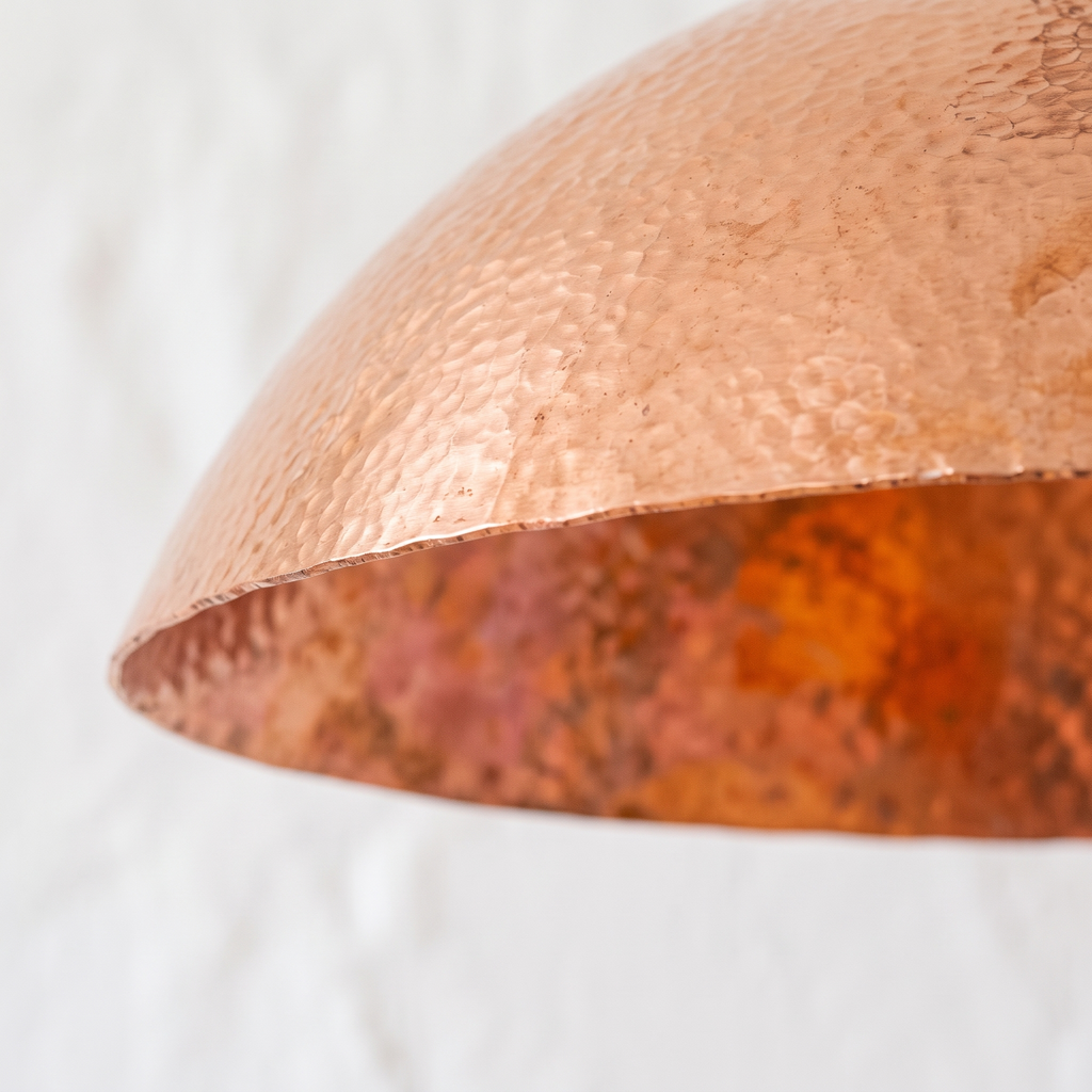 Hammered copper texture and mottled interior of the wide dome pendant