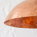 Hammered copper texture and mottled interior of the wide dome pendant