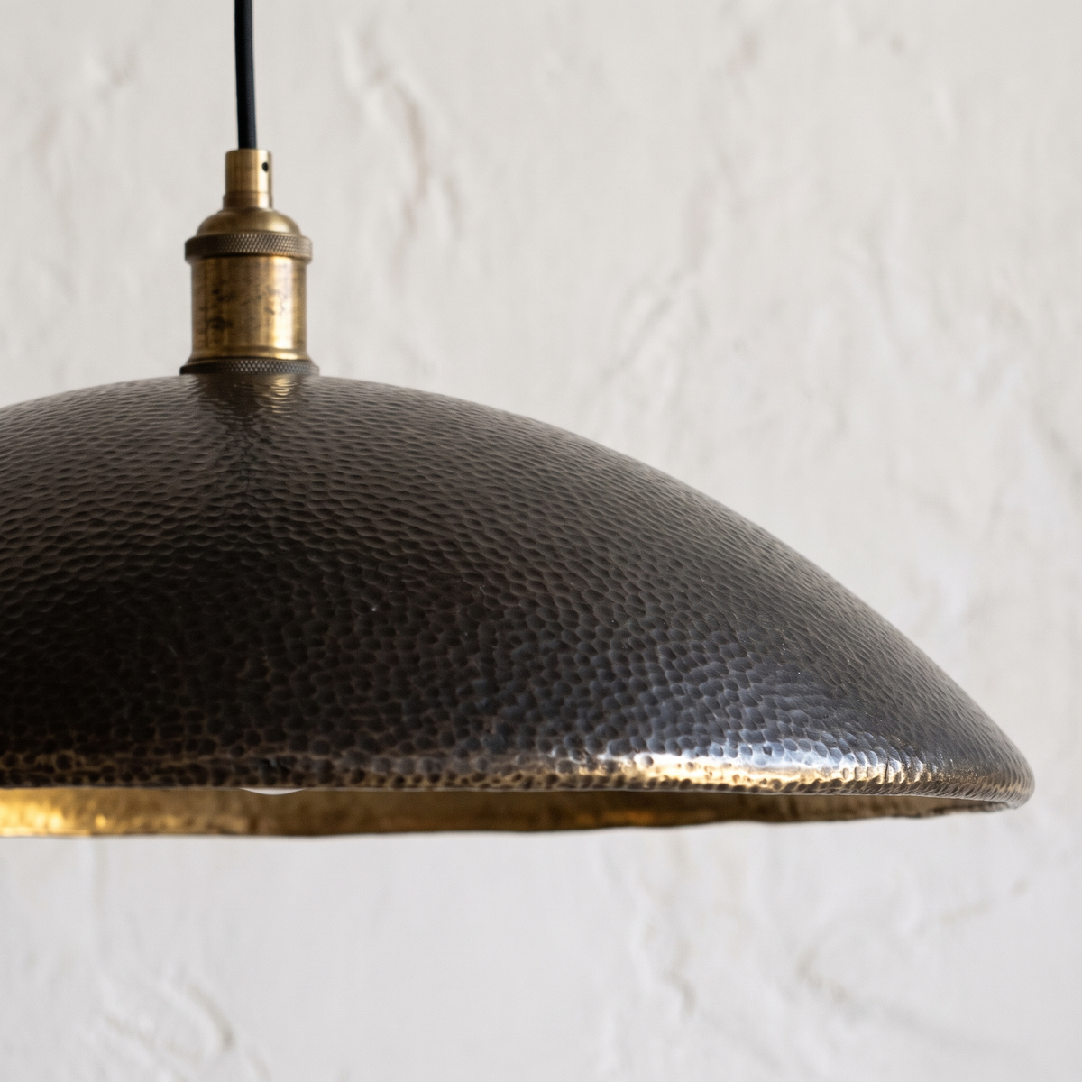 Close-up of the hammered dark bronze texture and bright brass rim