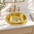 Hammered Oval Brass Drop-In Sink with Overflow installed in a bright bathroom