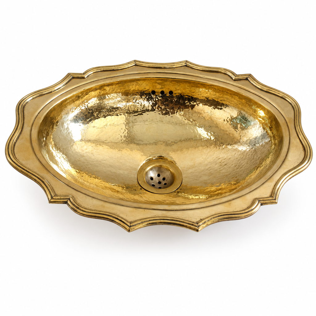 Hammered oval brass drop-in sink with scalloped rim on a white background