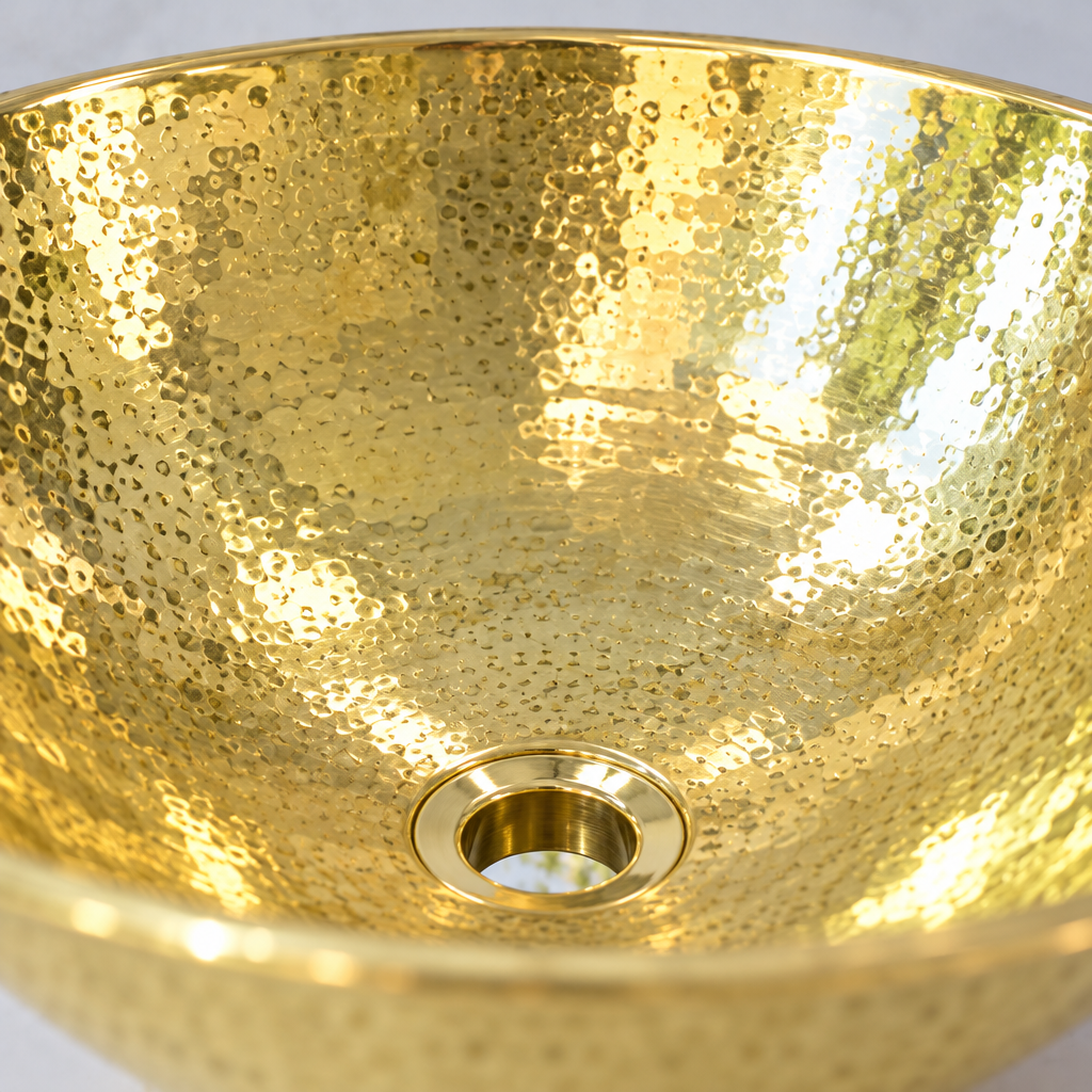 Hammered Oval Brass Vessel Sink, close-up of the hand-hammered polished brass and drain