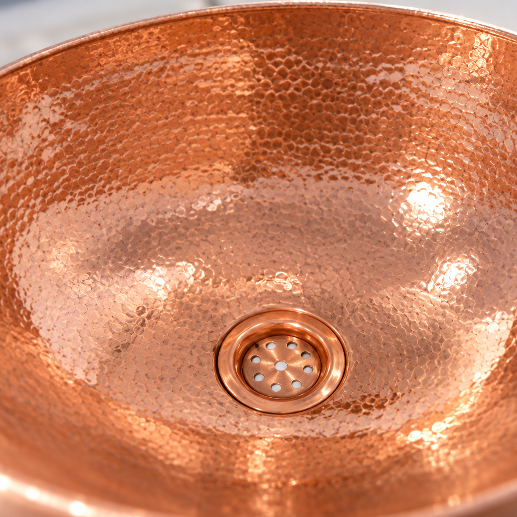 Hammered Oval Copper Vessel Sink close-up of the hammered copper and drain