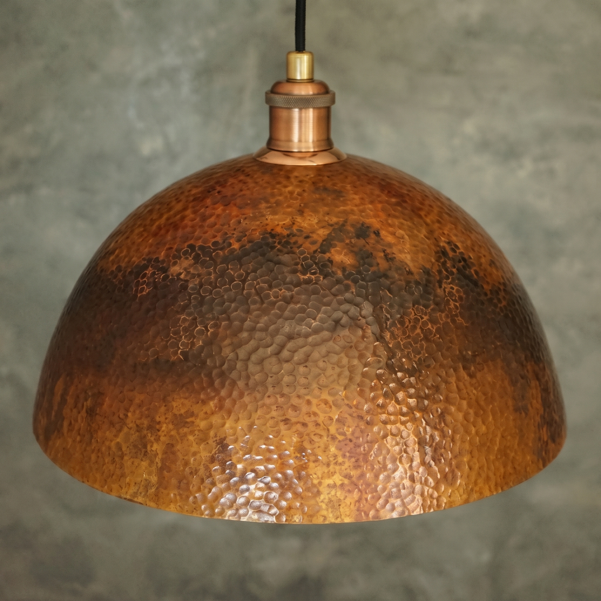 Hand-hammered texture and mottled oxidized copper patina of the dome pendant