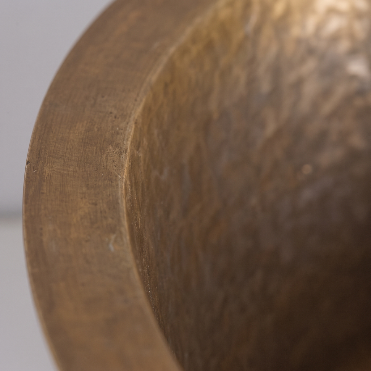 Close-up of the flat rim and hand-hammered aged brass texture of the prep sink