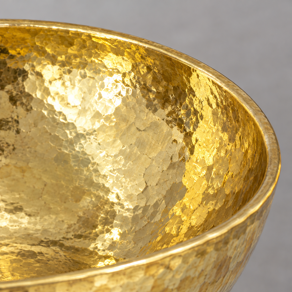 Close-up of the hammered round brass vessel sink showing the finish