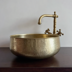 Side profile of the round hand-hammered brass vessel sink on a walnut counter