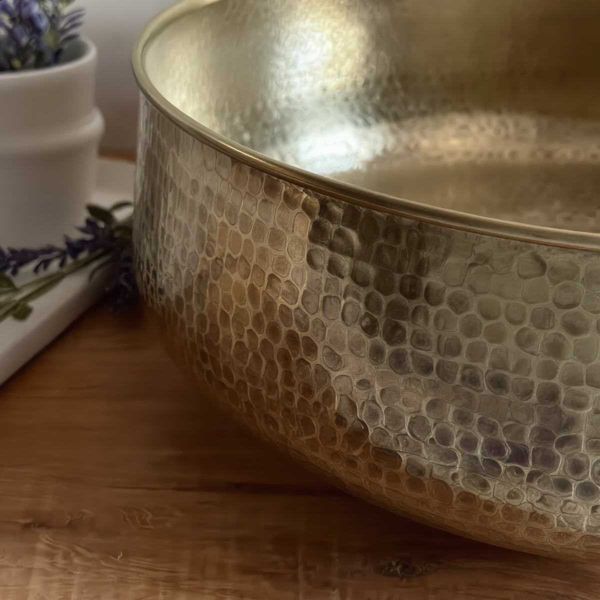 Close-up of the hammered texture and rim of the brass vessel sink