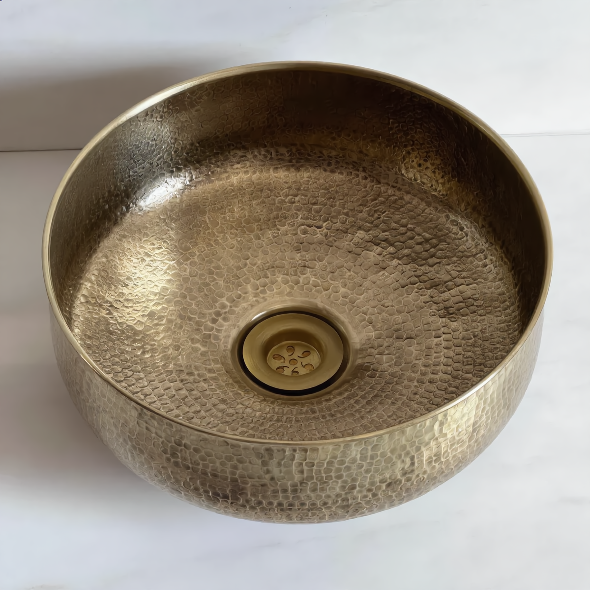 Top-down view of the brass vessel sink with its brass drain