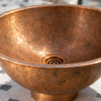 Lightly Hammered Copper Vessel Sink, Aged Finish close-up of the aged copper patina and drain