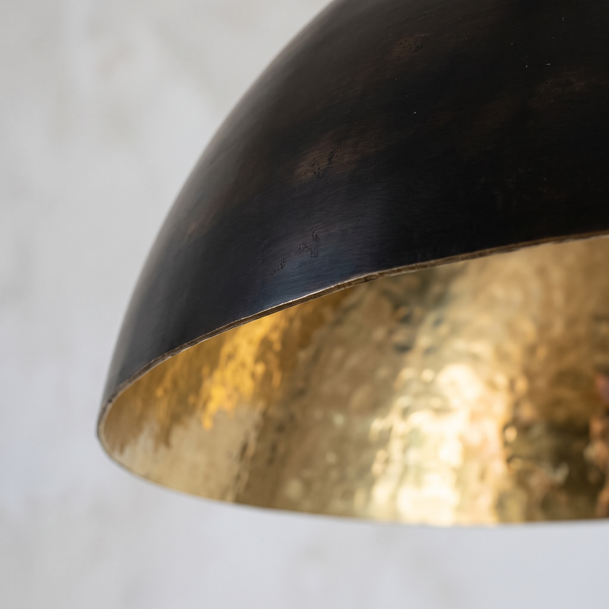 Close-up of the dark oiled exterior and hammered brass interior at the rim of the dome