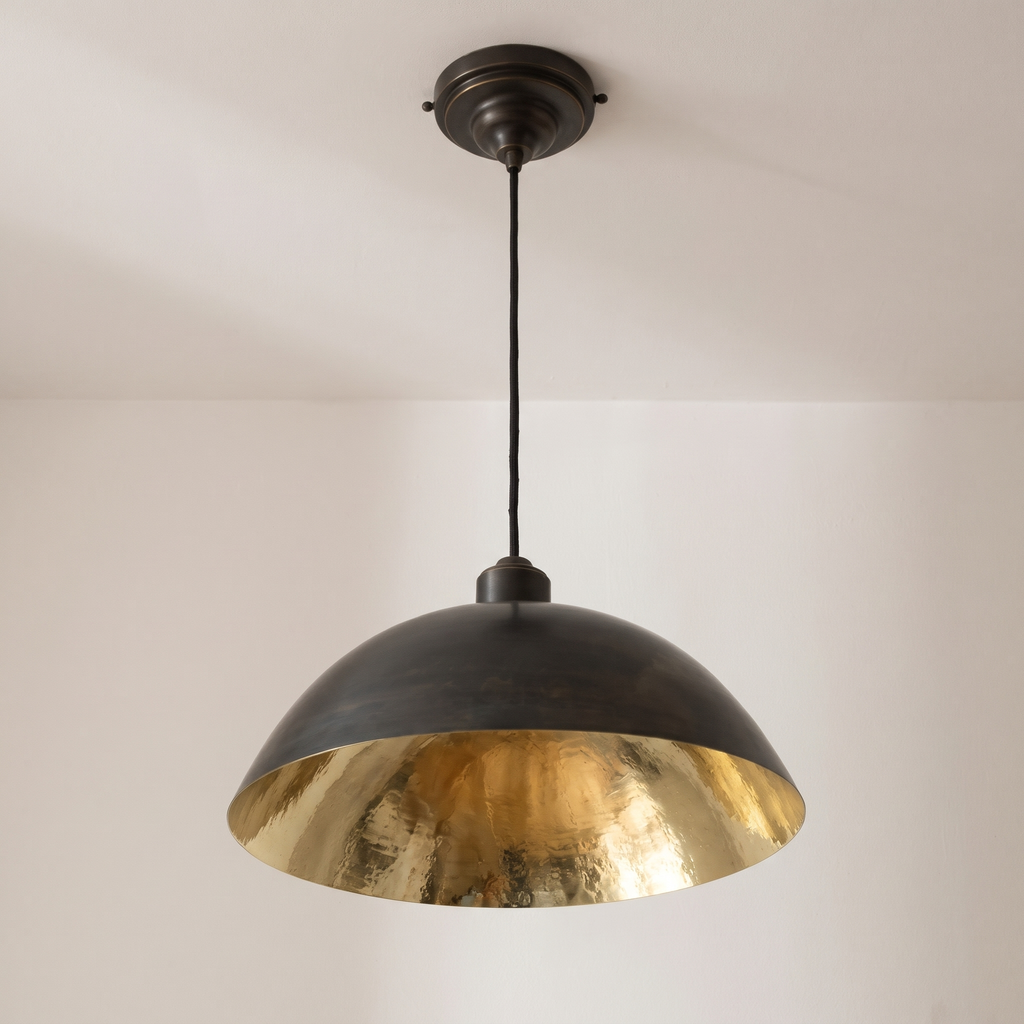 Oiled black brass dome pendant with hammered brass interior and black cord, light background