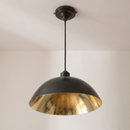 Oiled black brass dome pendant with hammered brass interior and black cord, light background