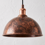 Close-up of the mottled oxidized copper patina on a dome shade