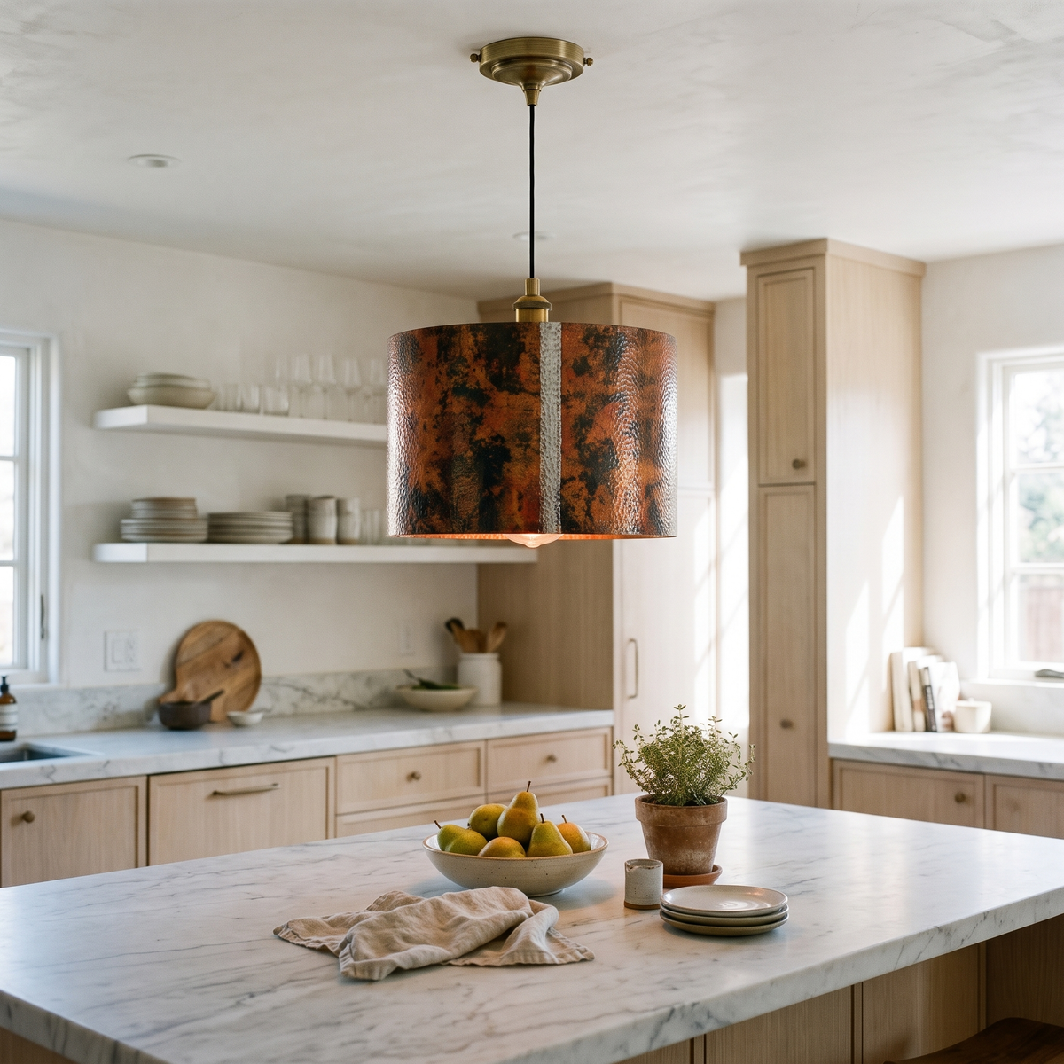Oxidized hammered copper drum pendant light over a white marble kitchen island