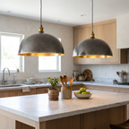 Two two-tone hammered brass dome pendant lights over a white marble kitchen island